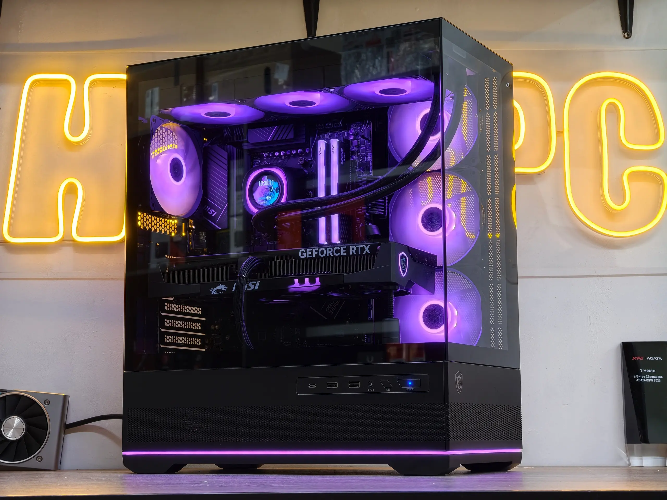 Игровая сборка HappyPC с жидкостным охлаждением на фоне вывески мастерской